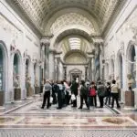 Visitors exploring art in museum gallery.